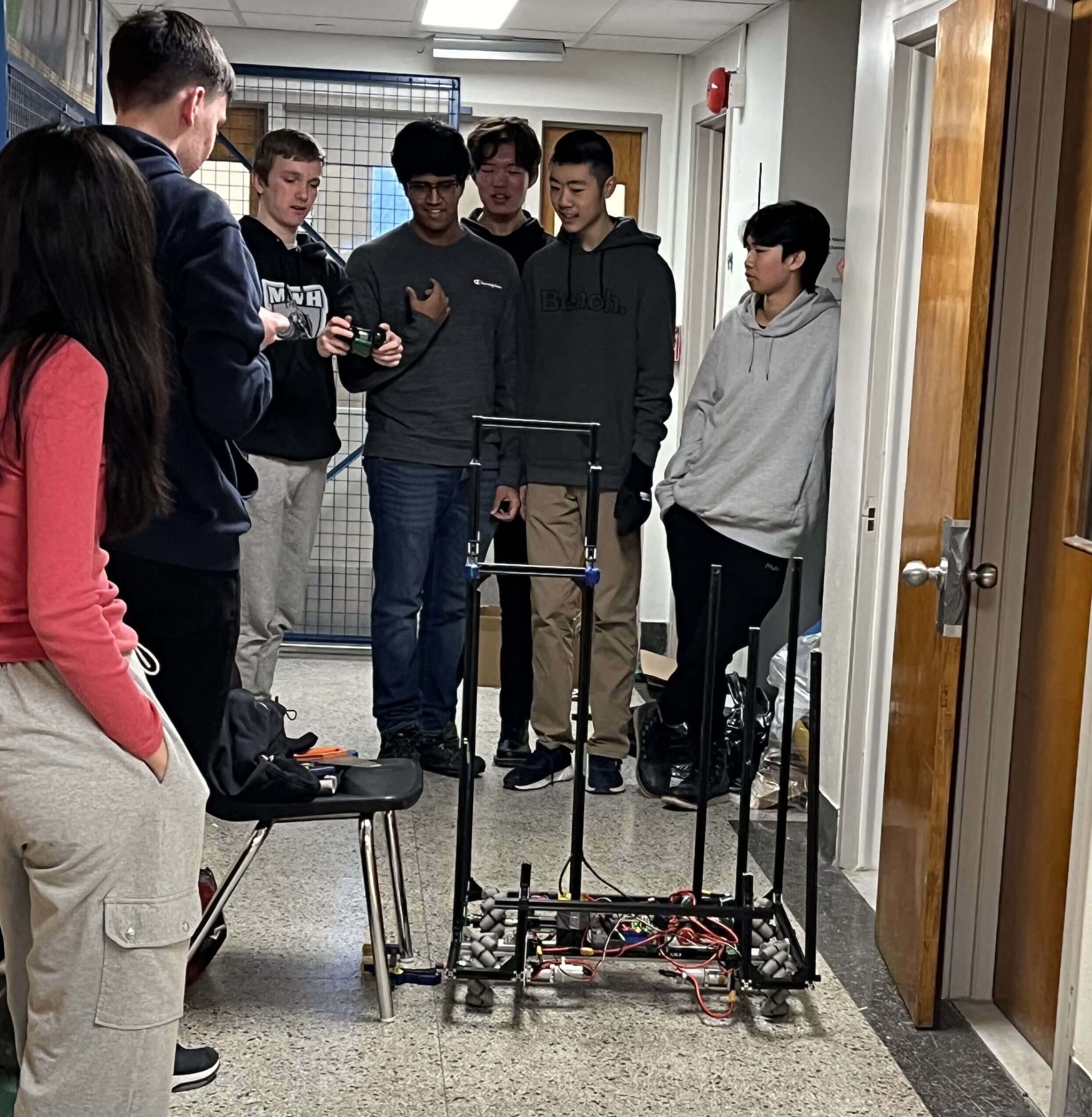 7 membres de l'équipe robot en train de conduire le robot sur une rampe.